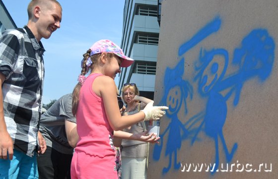 Юная художница создает свой первый граффити-рисунок